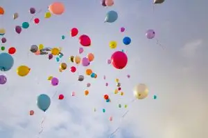 Vibrant balloons of various colors floating against a clear sky, creating a festive atmosphere.